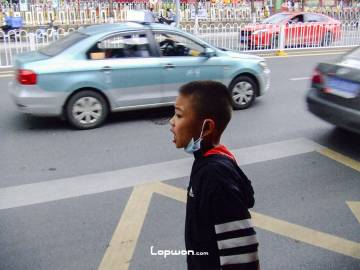 2021年07月30日,云南省昆明市,正在翘首等公交车的小孩。by Lopwon