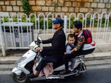 2021年07月31日，云南省昆明市，电动车上的人们。by Lopwon