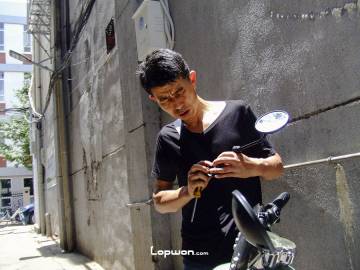 2021年07月29日，云南省昆明市，正在修理电动车的人。by Lopwon