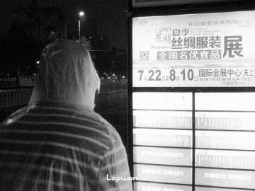 2021年08月13日，云南省昆明市，雨夜里查看公交车信息的人。by Lopwon